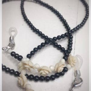 A chain for glasses made of black stones with cream roses and pebbles between them.