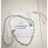 A chain for glasses made of blue glass stones and beige between them on a linen packaging bag.