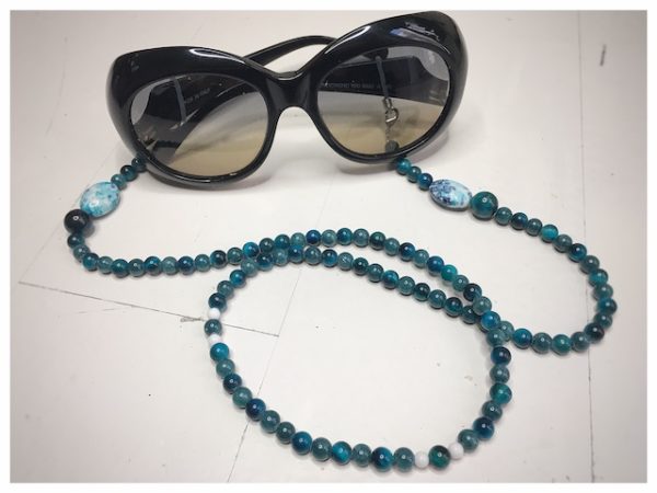 A chain for glasses of turquoise color with a white-turquoise larger stone.