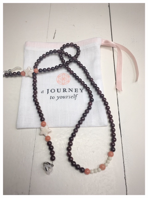 A chain for glasses made of maroon stones with beige stars between orange stones.