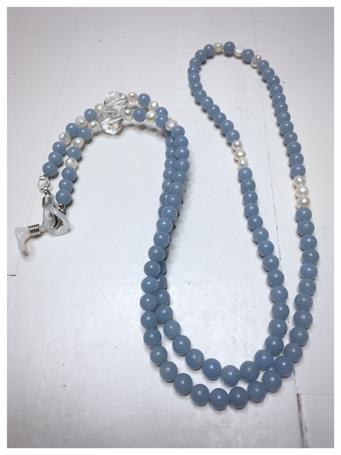 Łańcuszek do okularów dobro to obrazek jasnoniebieskiego łańcuszka z kamieni naturalnych z perłami i przezroczystymi kryształami.