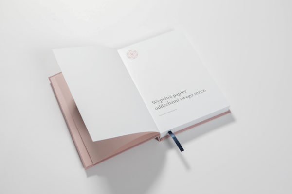 Dziennik Podroży Duchowej to zdjęcie różowego notatnika oprawionego w płótno na białym tle.